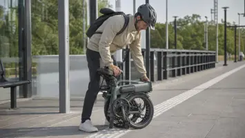 Opgevouwen elektrische vouwfiets naast een treinperron